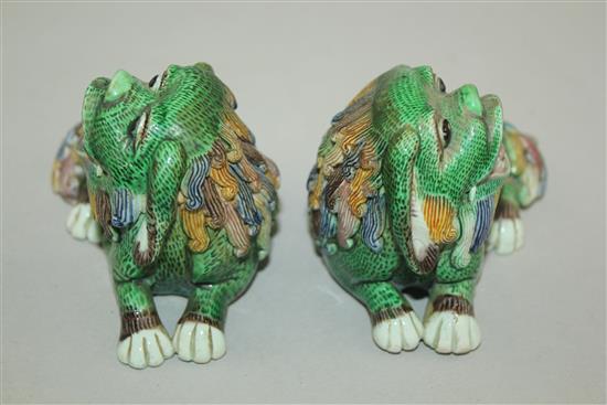 A pair of Chinese famille verte glazed biscuit figure of recumbent lion-dogs, 19th century, 10cm